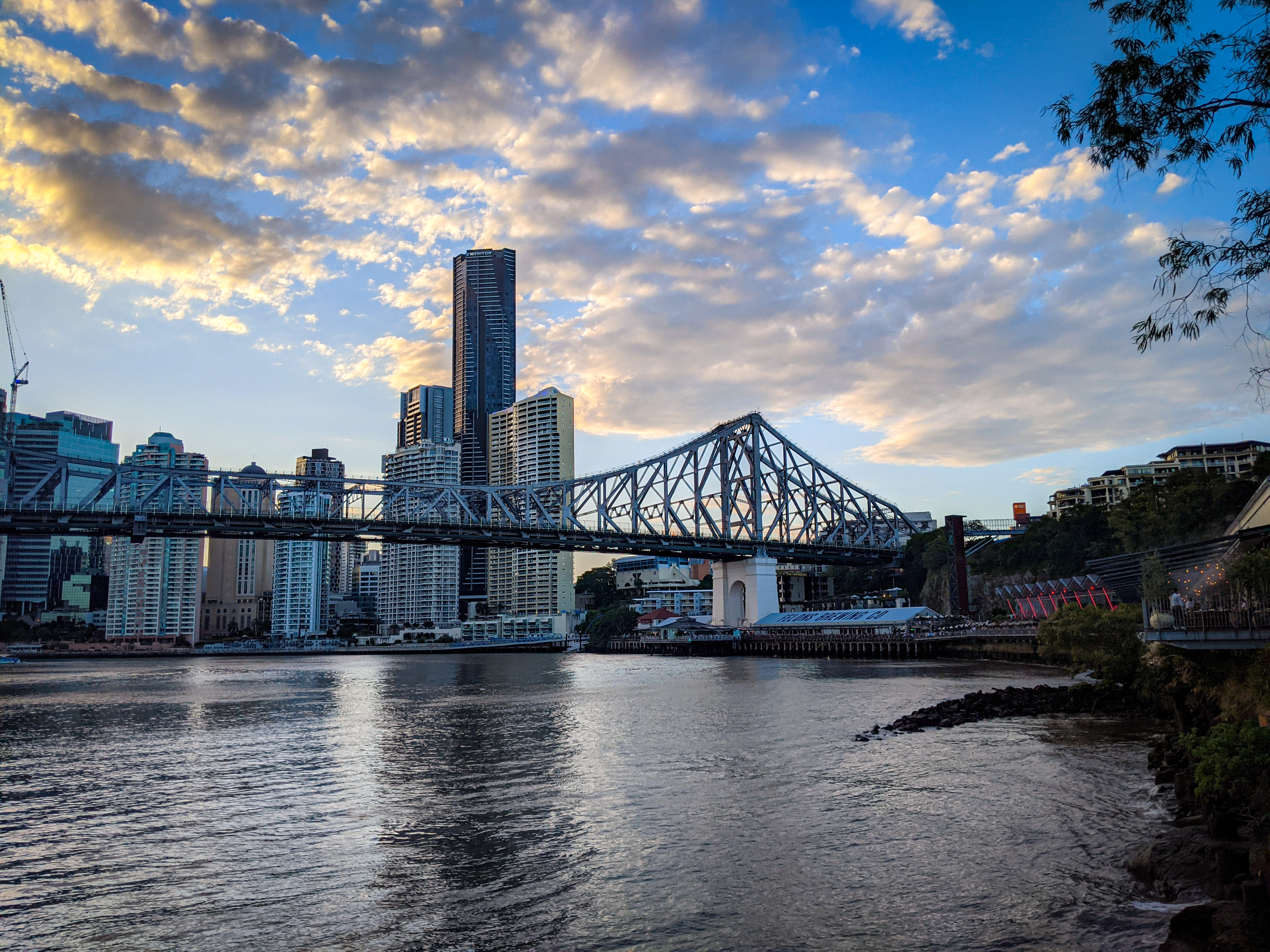 The sun setting over the Howard Smith Wharves from New Farm Riverwalk